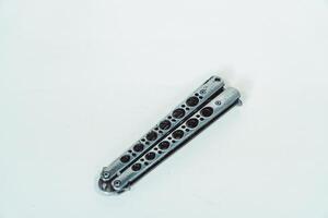 Partially open silver balisong or butterfly knife isolated on white background. Close-up of a sharp balisong knife or butterfly knife in various positions on a white background photo