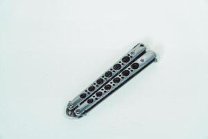 Partially open silver balisong or butterfly knife isolated on white background. Close-up of a sharp balisong knife or butterfly knife in various positions on a white background photo