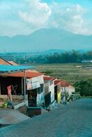 Residential area with beautiful views with a backdrop of green rice fields and mountains that look magnificent from a distance. Public housing complex on hills with sloping land with mountain views photo