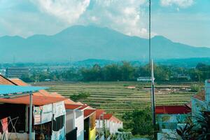 Residential area with beautiful views with a backdrop of green rice fields and mountains that look magnificent from a distance. Public housing complex on hills with sloping land with mountain views photo