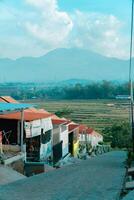 Residential area with beautiful views with a backdrop of green rice fields and mountains that look magnificent from a distance. Public housing complex on hills with sloping land with mountain views photo