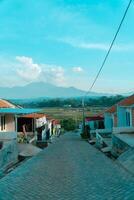 Residential area with beautiful views with a backdrop of green rice fields and mountains that look magnificent from a distance. Public housing complex on hills with sloping land with mountain views photo