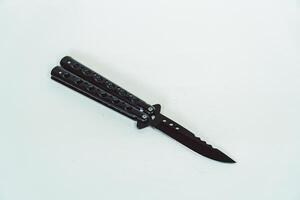 Partially open matte black balisong or butterfly knife isolated on white background. Close-up of a sharp balisong knife or butterfly knife in various positions on a white background photo