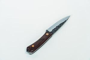 Close up of an adventure and bushcraft knife using a wooden handle. Knife with a sharp stainless steel blade with a wooden handle, perfect for outdoor adventures and bushcraft activities photo