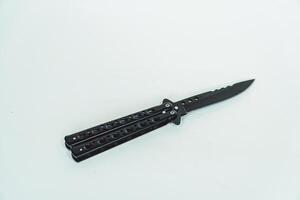 Partially open matte black balisong or butterfly knife isolated on white background. Close-up of a sharp balisong knife or butterfly knife in various positions on a white background photo