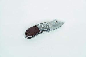 Close up of an adventure and bushcraft knife using a wooden handle. Knife with a sharp stainless steel blade with a wooden handle, perfect for outdoor adventures and bushcraft activities photo