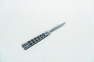 Partially open silver balisong or butterfly knife isolated on white background. Close-up of a sharp balisong knife or butterfly knife in various positions on a white background photo