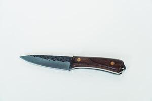 Close up of an adventure and bushcraft knife using a wooden handle. Knife with a sharp stainless steel blade with a wooden handle, perfect for outdoor adventures and bushcraft activities photo