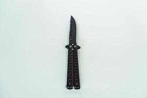 Partially open matte black balisong or butterfly knife isolated on white background. Close-up of a sharp balisong knife or butterfly knife in various positions on a white background photo