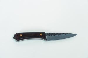 Close up of an adventure and bushcraft knife using a wooden handle. Knife with a sharp stainless steel blade with a wooden handle, perfect for outdoor adventures and bushcraft activities photo