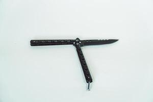 Partially open matte black balisong or butterfly knife isolated on white background. Close-up of a sharp balisong knife or butterfly knife in various positions on a white background photo