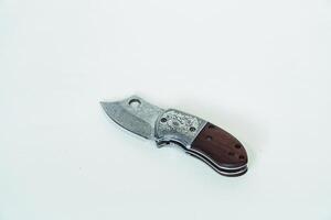 Close up of an adventure and bushcraft knife using a wooden handle. Knife with a sharp stainless steel blade with a wooden handle, perfect for outdoor adventures and bushcraft activities photo