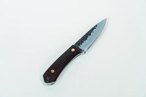 Close up of an adventure and bushcraft knife using a wooden handle. Knife with a sharp stainless steel blade with a wooden handle, perfect for outdoor adventures and bushcraft activities photo