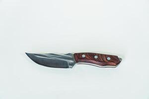 Close up of an adventure and bushcraft knife using a wooden handle. Knife with a sharp stainless steel blade with a wooden handle, perfect for outdoor adventures and bushcraft activities photo