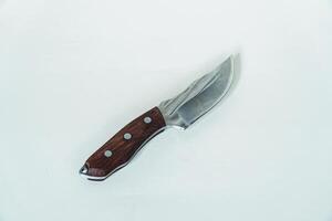 Close up of an adventure and bushcraft knife using a wooden handle. Knife with a sharp stainless steel blade with a wooden handle, perfect for outdoor adventures and bushcraft activities photo