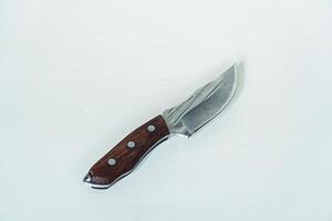 Close up of an adventure and bushcraft knife using a wooden handle. Knife with a sharp stainless steel blade with a wooden handle, perfect for outdoor adventures and bushcraft activities photo