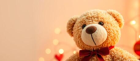 Cute teddy bear with red bow tie on a light pink background photo