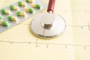 Stethoscope on electrocardiogram ECG, heart wave, heart attack, cardiogram report. photo