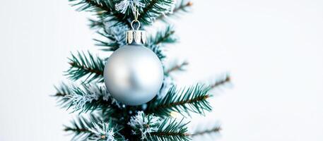 Silver Christmas Ornament Hanging on a Pine Tree Branch photo