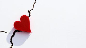 Red Heart on a White Background with a Crack photo
