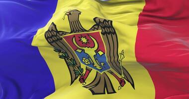 Moldova flag waving at wind in slow in blue sky, loop video