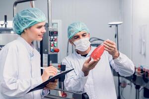 Quality control and food safety inspector test and check product contaminate standard in the food and drink factory production line with hygiene care. photo
