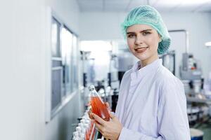 Portrait happy beverage factory worker. Drinks safety inspector in the food and drink factory production line with hygiene. photo