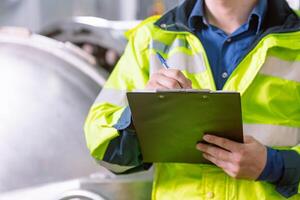 Technician engineer routine working monitor temperature in boiler room work in plant industry, Technician Staff checking check list. photo