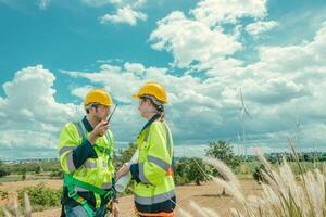 Engineer team man and women workers Wind Turbines service team working together at wind electricity generator farm field. photo