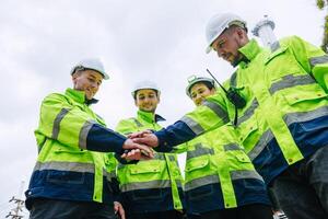 Group of Refinery Engineer team workers Join Hand for Collaboration Working. Industrial Worker Mix Together. Workers hands meeting job successfully. photo