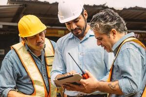 Professional construction engineer workers team working cooperate together consulting looking at tablet screen at project building construction site. photo