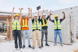 Group of workers teamwork in construction industrial plant. Diverse workers standing together. Happy cheerful Industrial engineer people team concept. photo