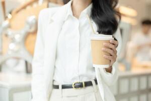 Closeup business people handle paper hot coffee cup, saving environment using recycle drink container concept. photo