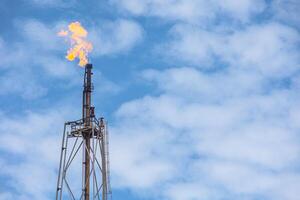 Methane Gas Fire High Flare Stack Flaring Tower Platform in Refinery Petroleum Plant or Flame Burn On Offshore Oil Extraction Process. photo