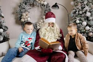 Santa claus entertaining children with a storybook while seated on a cozy sofa photo
