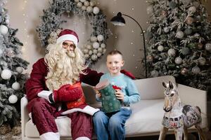 Santa claus giving christmas gift to a happy child photo