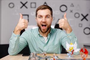 Man with board game piece while practicing strategy in home alone. A man plays a board game with cards and figures, expressing different emotions photo