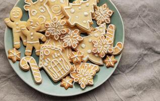 Christmas cookies with white icing forming various shapes lying on a plate photo