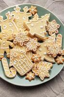 Christmas cookies with white icing forming various shapes lying on a plate photo
