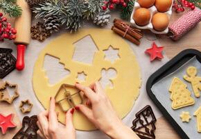 Pastry chef making christmas cookies using dough cutters photo