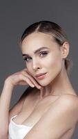 Beautiful young, american woman with clean, glow, flawless skin posing against dark studio background. Female portrait healthy complexion, skincare cosmetology and cosmetics advertising concept photo