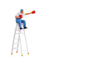 A miniature figurine of a painter seated on a ladder, holding a paint can and brush.isolate on white back ground with clipping path photo