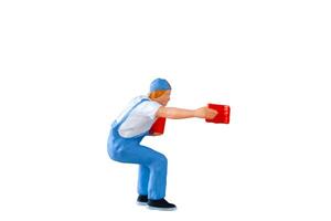 A miniature figurine of a painter holding a paint can and brush isolate on white background with clipping path photo