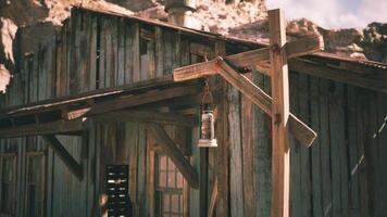 Rustic wooden building with a lantern hanging outside in a desert setting video