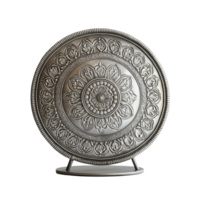 Decorative metal disc with intricate floral pattern displayed on a bright surface, A decorative metal object on a surface, transparent background. png