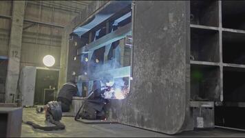 Welding of metal structures at industrial plant. Stock clip. Welding assembly of large metal structure to order at industrial enterprise. Worker welds metal structure at factory video