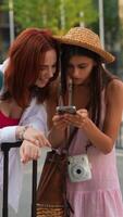 Two young women engaged in lively interaction while using a smartphone in an urban environment video