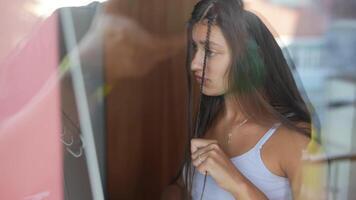 A Thoughtful Young Woman Engaged in a Deeply Introspective Moment by the Window Enjoying the View video