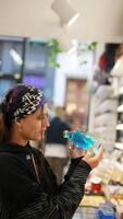 un joven individual pensativamente revisando un producto mientras en un Al por menor Tienda ambiente video