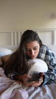 A Young Woman Is Relaxing Comfortably at Home While Using Her Smartphone to Browse Various Things video